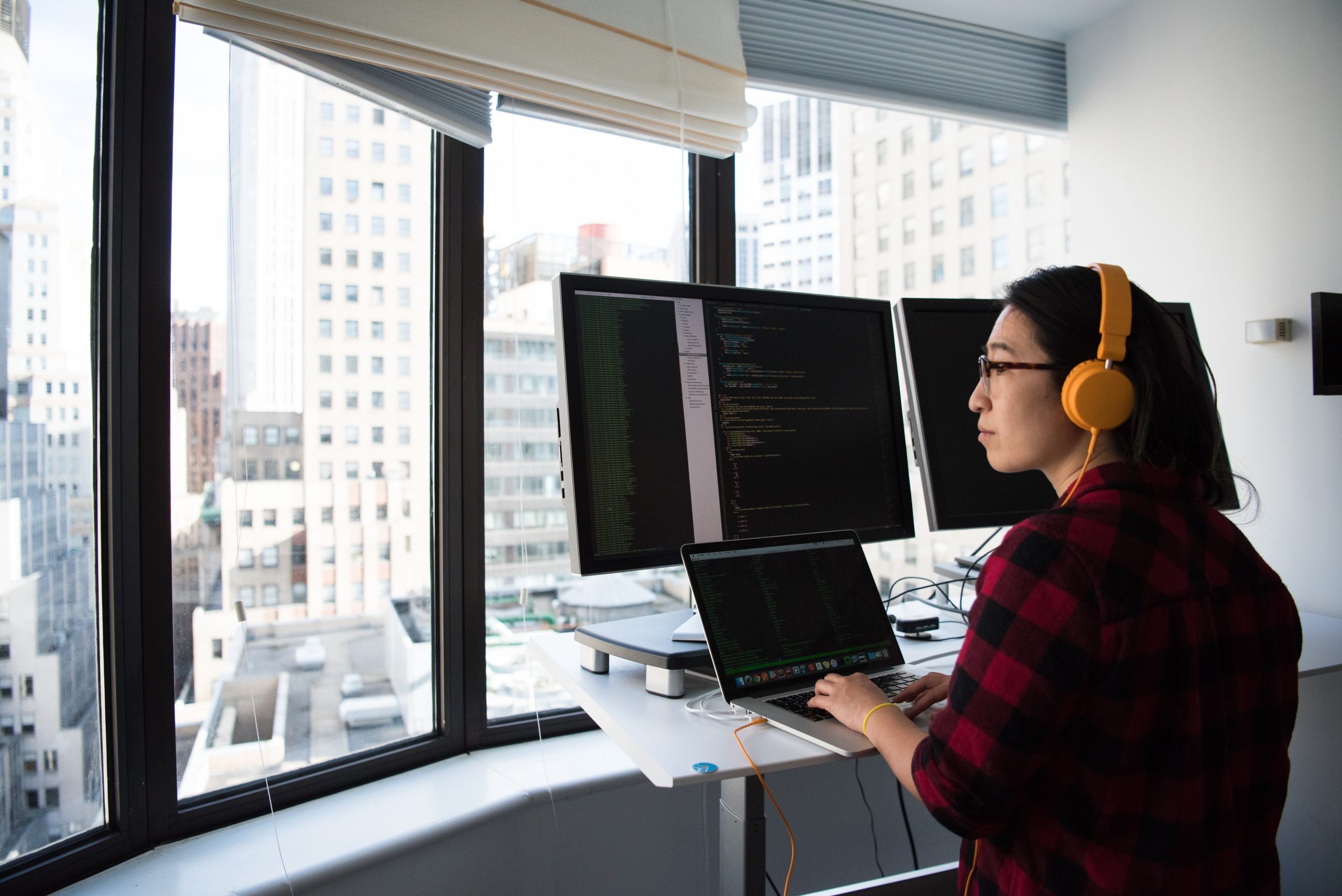 A woman standing in front of computer doing computer and server maintenance